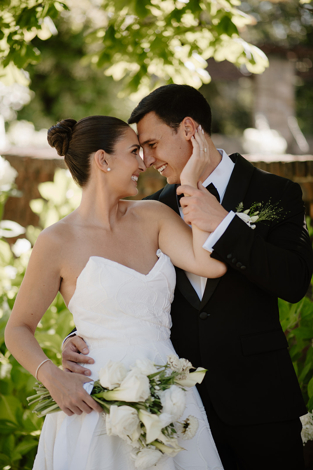 Close-up of the bride and groom smiling warmly and touching foreheads during their portraits.